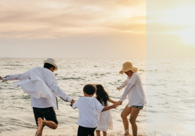Famiglia felice gioca sulla spiaggia al tramonto.